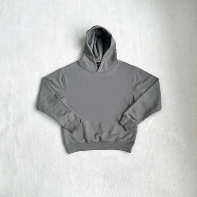 A complete grey pullover hoodie with a kangaroo pocket, laid flat against a pale textured background