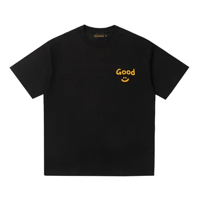 A plain black short-sleeved tee laid flat, with a small yellow smiley and the word Good printed at chest height